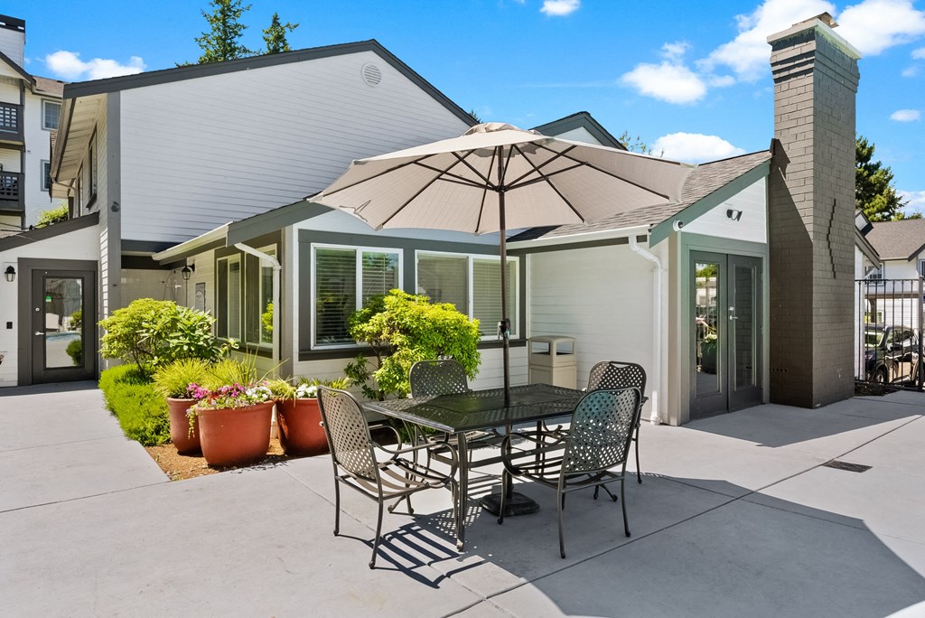 a patio with a table and chairs under an umbrella