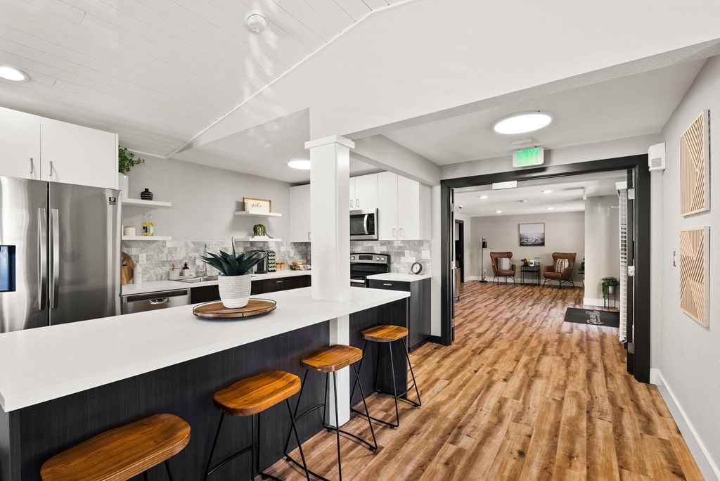 a kitchen with a white counter top and wooden floors