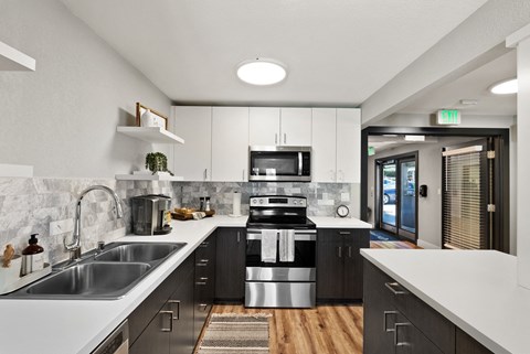 an open kitchen with white counter tops and black and white appliances