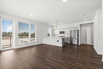 A spacious kitchen with a refrigerator, sink, and stove is visible.