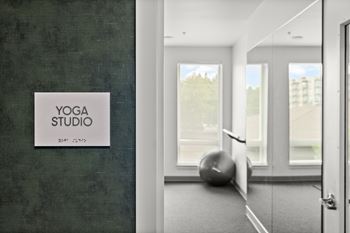 A yoga studio sign is on a wall next to a door.