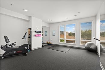 A spacious room with a treadmill, exercise ball, and yoga mat.