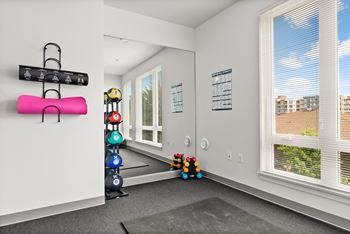 A room with a white wall and a window with blinds.