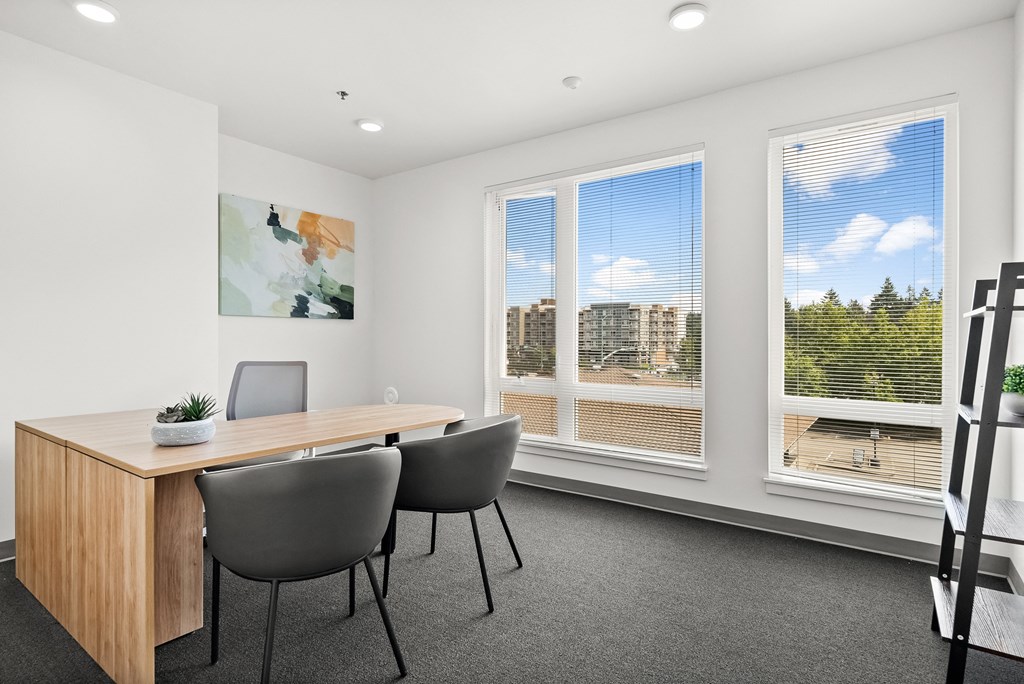 a meeting room with a wooden table and grey chairs