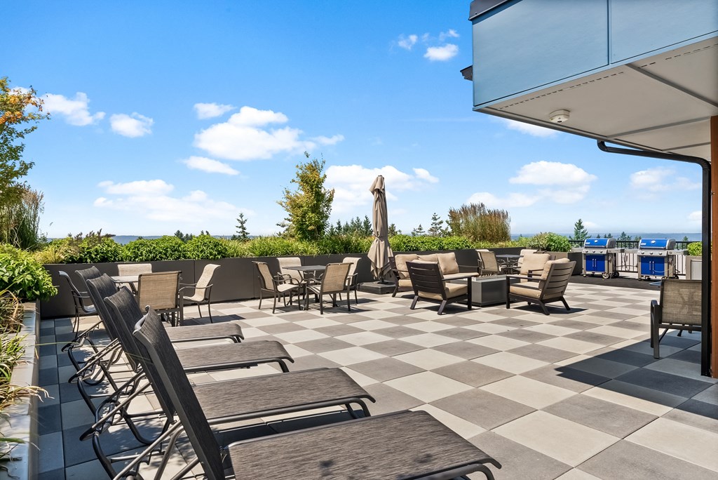 an outdoor patio with chairs and tables on a checkered tile floor