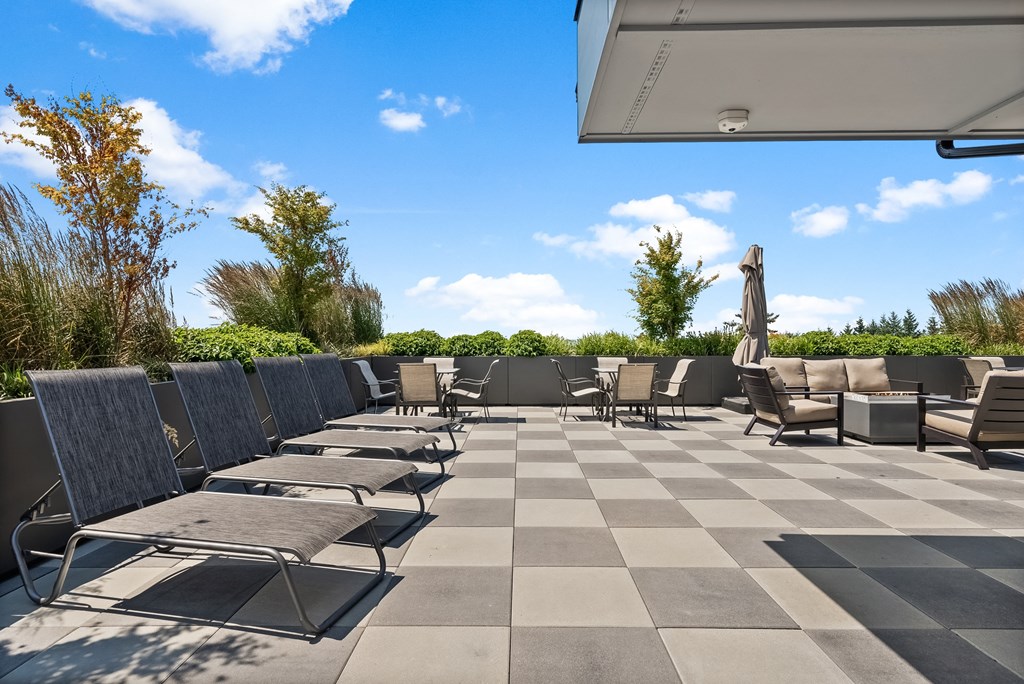 an outdoor patio with lounge chairs and umbrellas on a sunny day