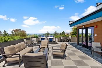 A patio with chairs and a table overlooking the ocean.
