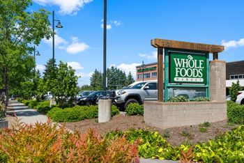 A Whole Foods sign is in front of a parking lot.