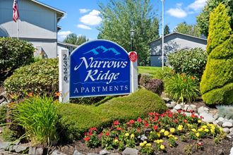 the sign for narrowness ridge apartments in front of a flower garden