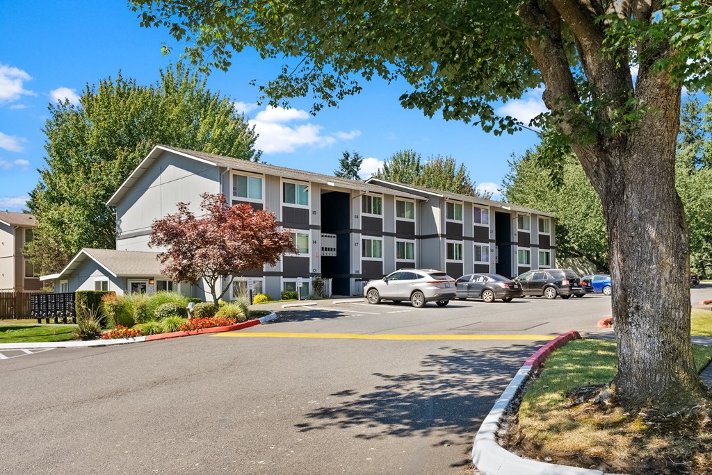 an apartment building with cars parked in front of it