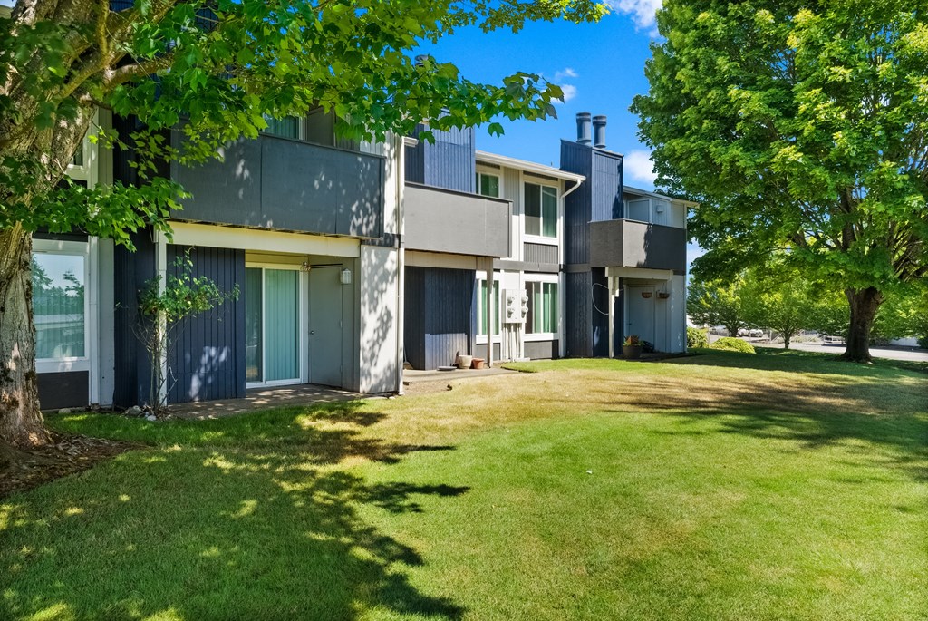 a view of a house with a yard and trees
