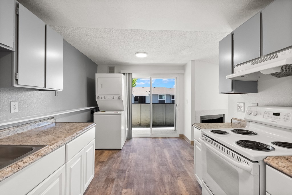 an empty kitchen with white appliances and white cabinets