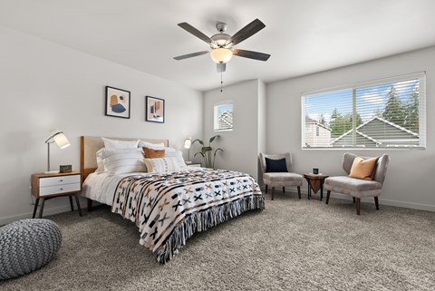 A bedroom with a large bed and a ceiling fan.