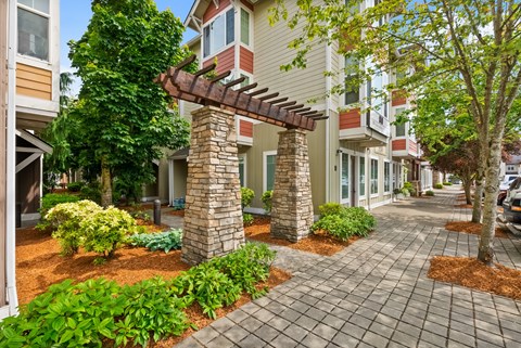 a brick sidewalk in front of a building with trees