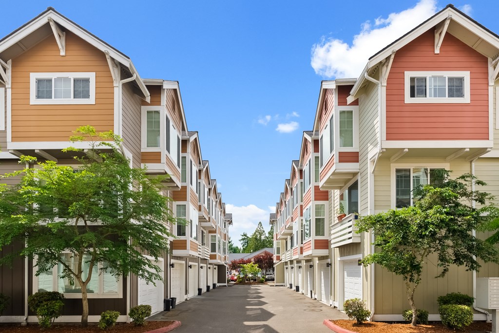 a row of townhomes with a street in front of them