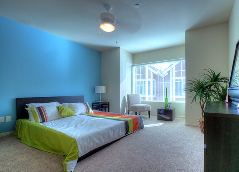 a bedroom with a bed and a large window