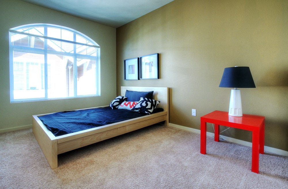 a bedroom with a bed and a red table