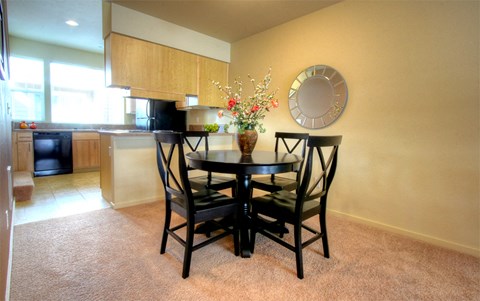 a dining room with a table and chairs and a kitchen