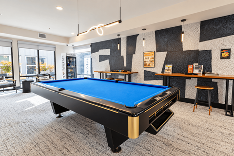 A pool table in a room with a black and white wall.