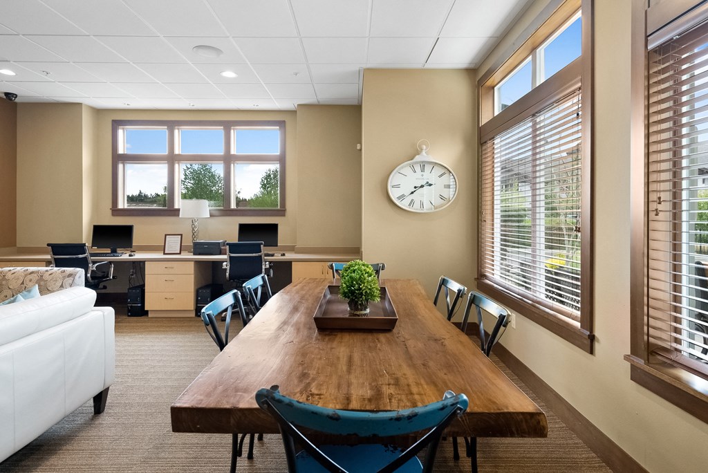 a conference room with a table and chairs and a clock on the wall