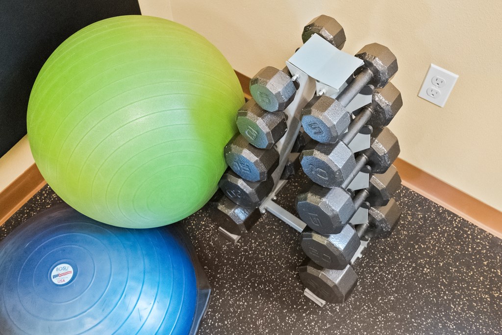 a large ball and weights on a wall next to a gym ball