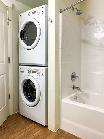 A white washer and dryer in a Ruth Court apartment bathroom.