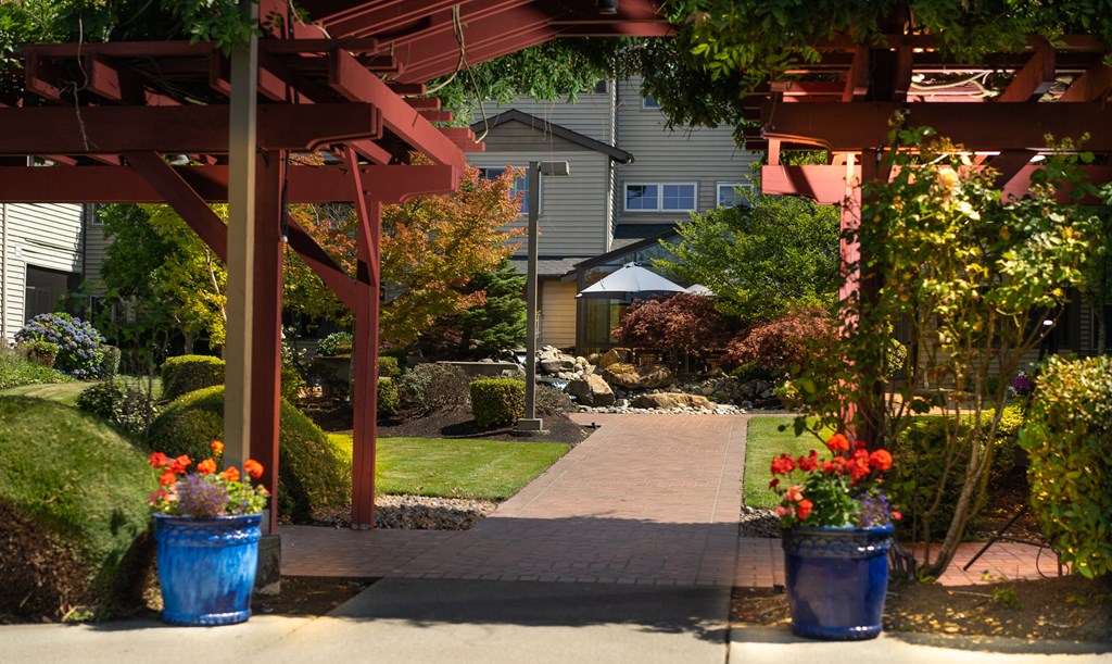 a view of a garden with a walkway and a red structure