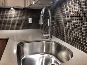 A stainless steel kitchen sink with a chrome faucet.