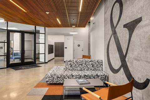 A modern office lobby with a large ampersand on the wall.