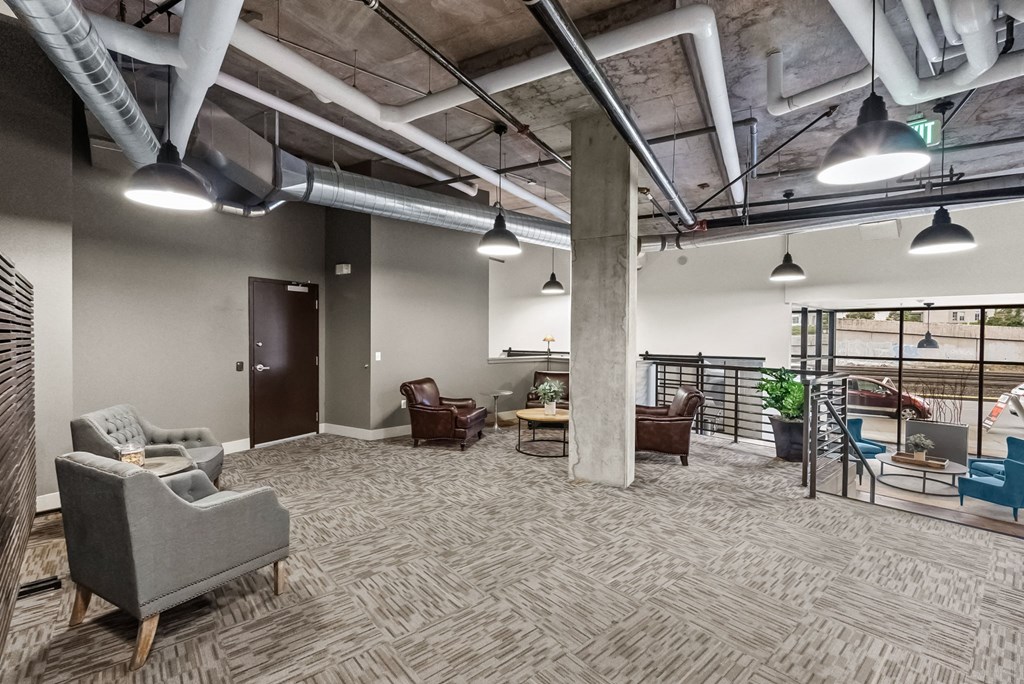 A spacious office with grey carpeting and a variety of seating options.