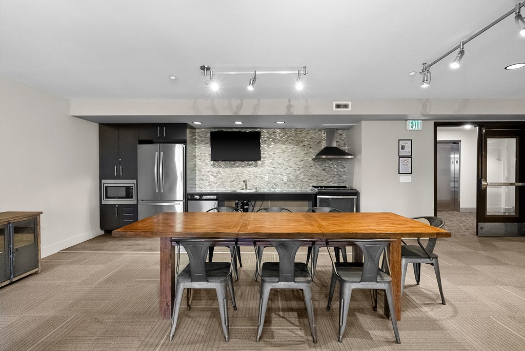 A modern kitchen with a wooden table and chairs.