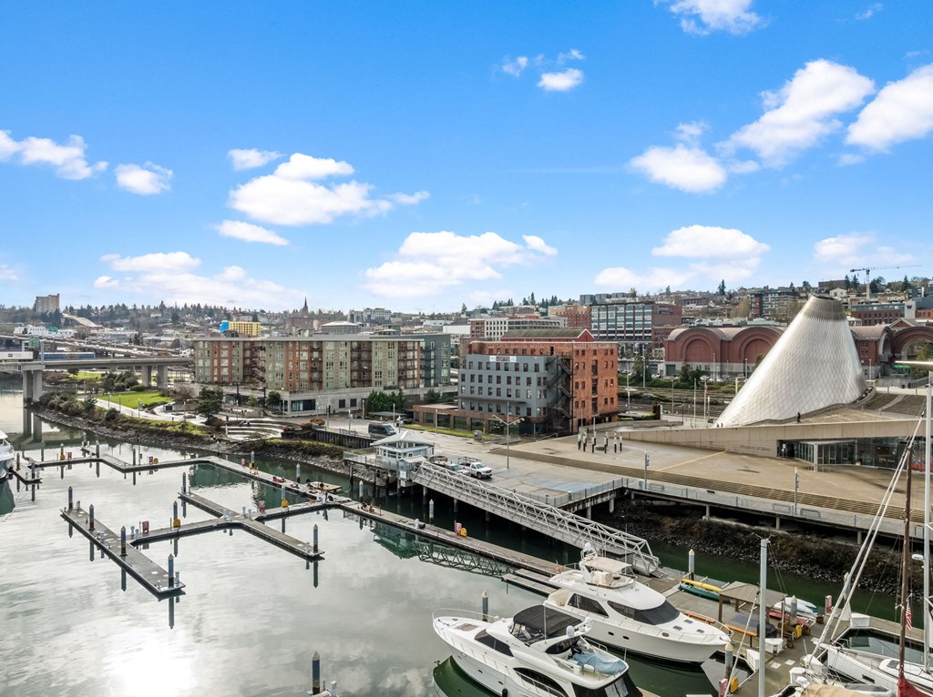 A cityscape with a boat docked at a pier.at The Henry, Tacoma
