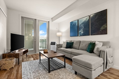 A living room with a grey couch and a coffee table.