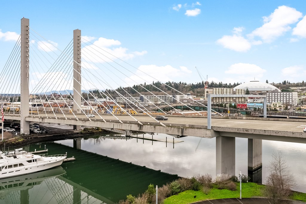 A bridge over a body of water with a boat underneath it.at The Henry, Tacoma, WA 98402