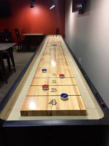 A shuffleboard game with numbers 1 to 4 on the wood.