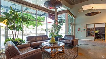 A living room with brown leather furniture and a large window.