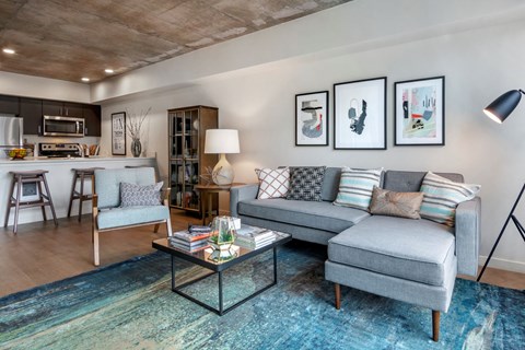 A modern living room with a grey sofa and a coffee table.
