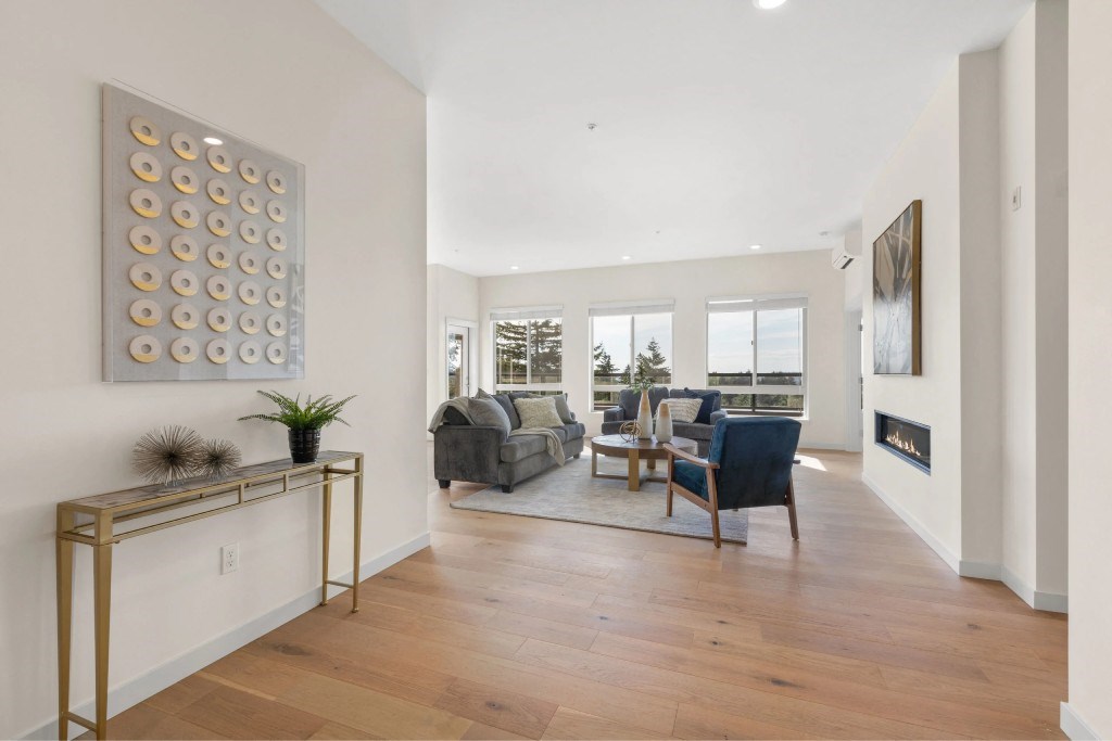A living room with a fireplace and a painting on the wall.