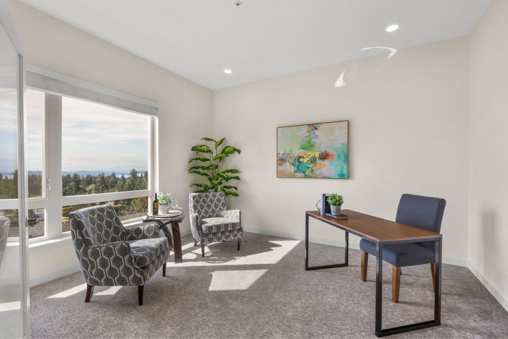 A room with a table and chairs and a painting on the wall.