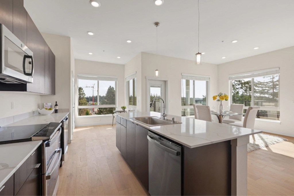 A modern kitchen with a large island and stainless steel appliances.