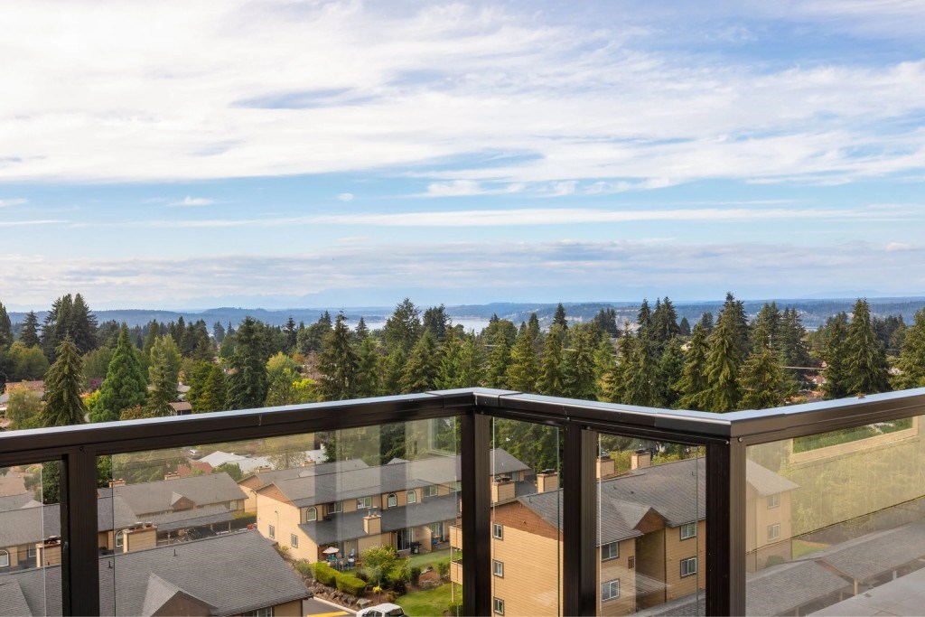 A balcony overlooks a residential area with houses and trees.