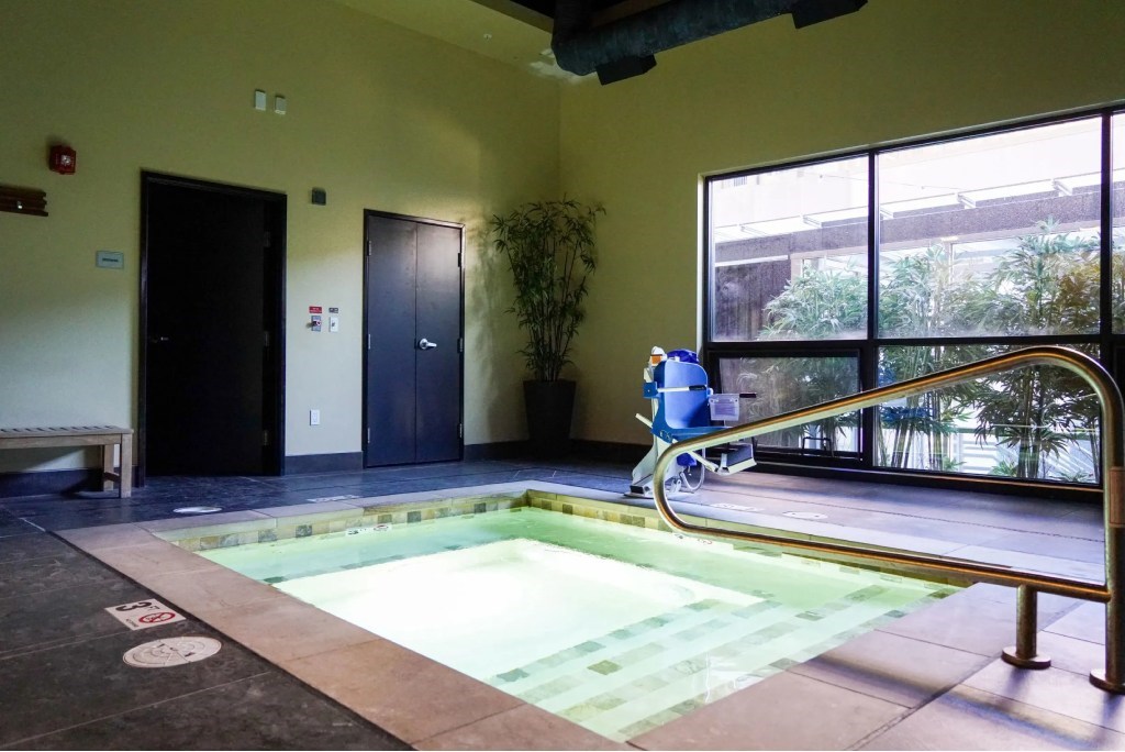 A small indoor pool with a metal railing.