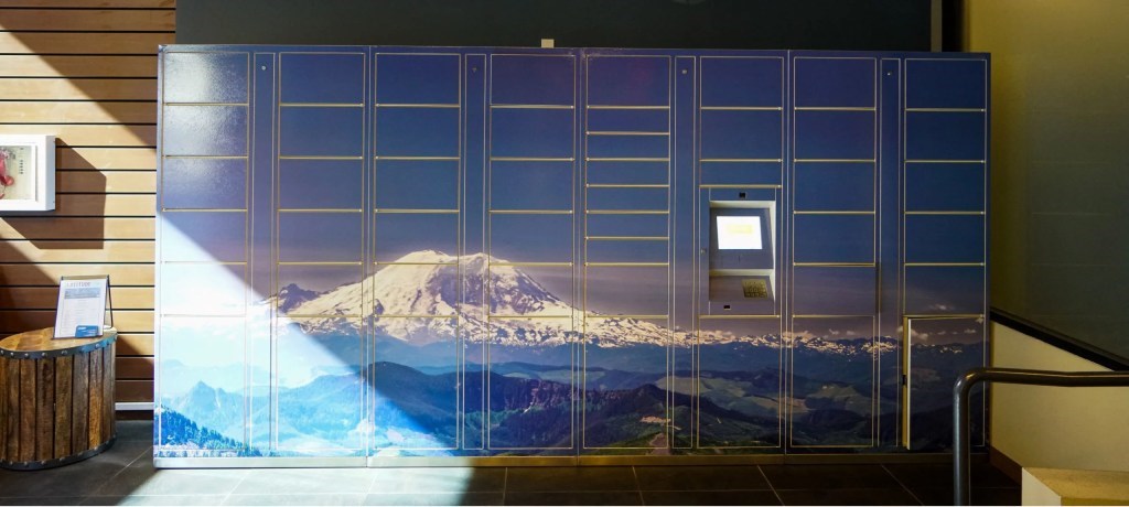 A wall with a picture of a mountain and a window.