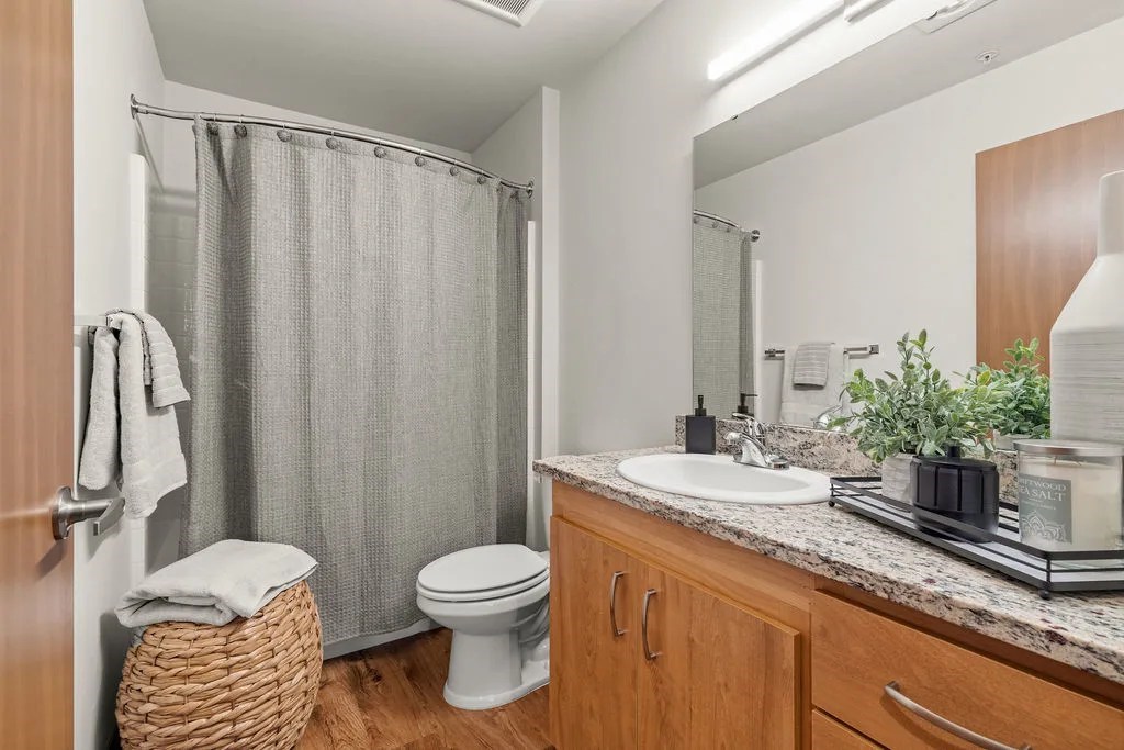 A bathroom with a toilet, sink, and shower.