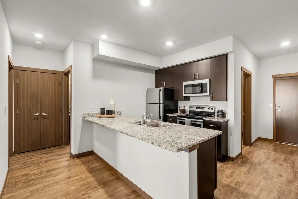 A kitchen with a granite countertop and stainless steel appliances.