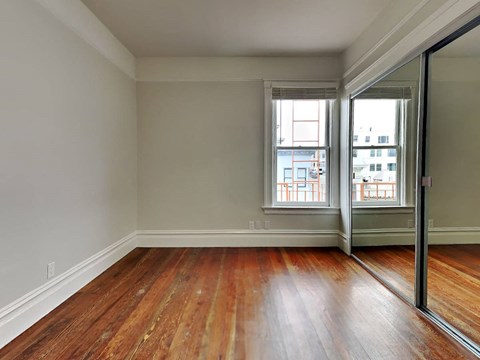an empty living room with wood floors and a sliding glass door