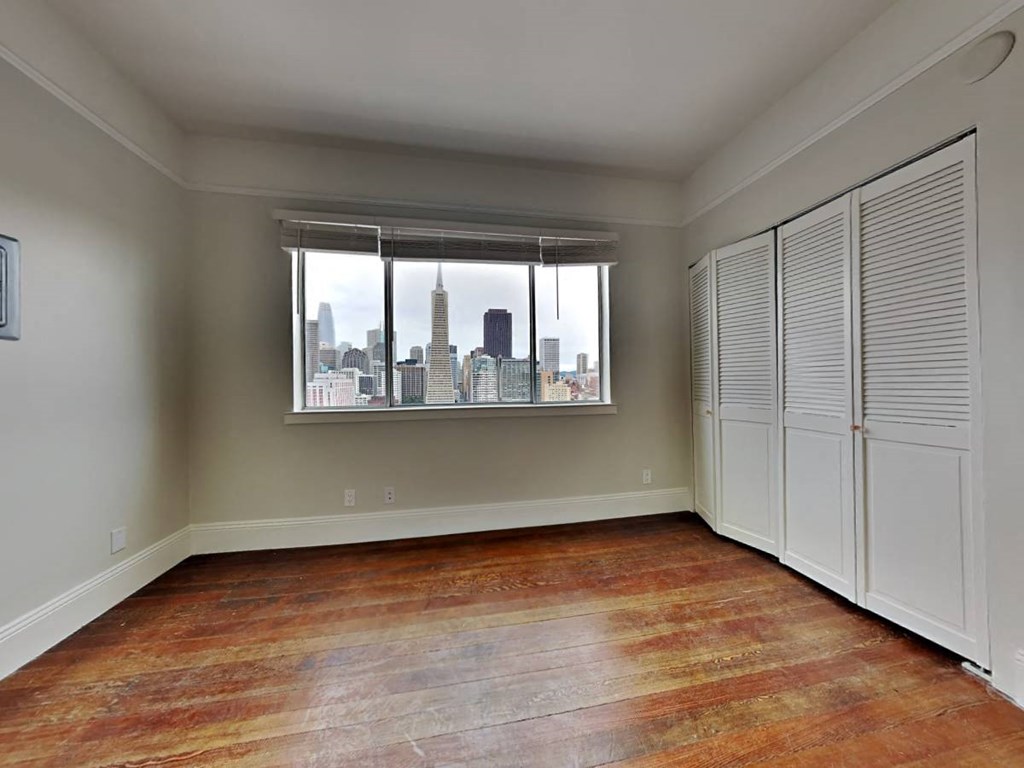 an empty living room with a window and a closet