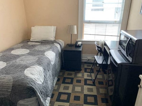 a small bedroom with a bed and a television