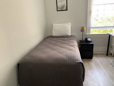 a small bedroom with a bed and a window