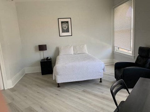 a bedroom with a bed and a chair and a table